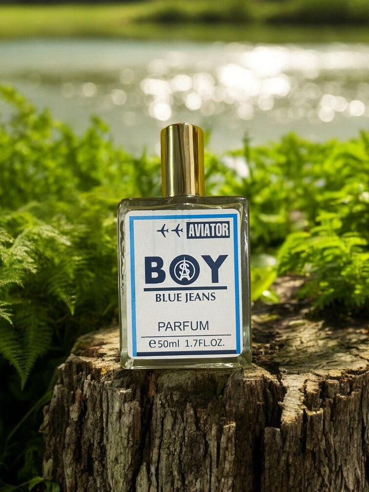 Superior eMart men's blue jeans fragrance 50ml bottle with gold cap on tree stump outdoors