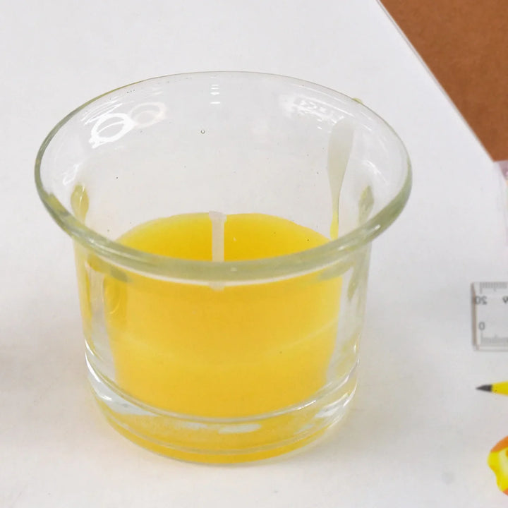 Diwali candle holder set featuring a decorative glass holder with a bright yellow candle inside