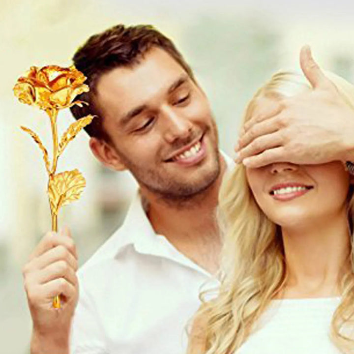 Smiling couple with a golden rose decoration, showcasing a romantic gift idea for special occasions