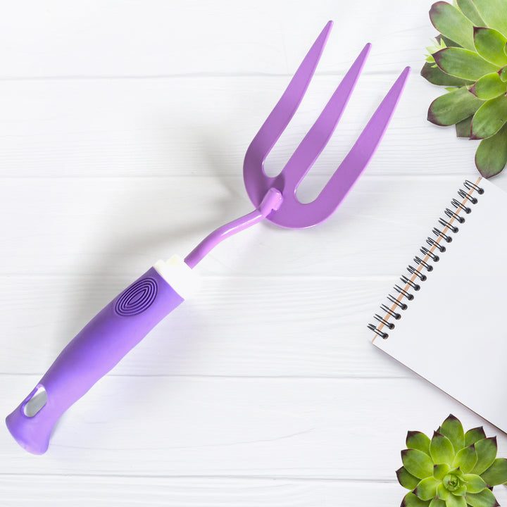 Heavy duty garden tools including a purple garden fork on a table with succulent plants