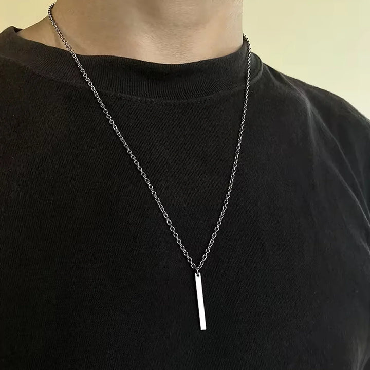 Stainless steel locket necklace featuring a sleek design worn by a person in a black shirt