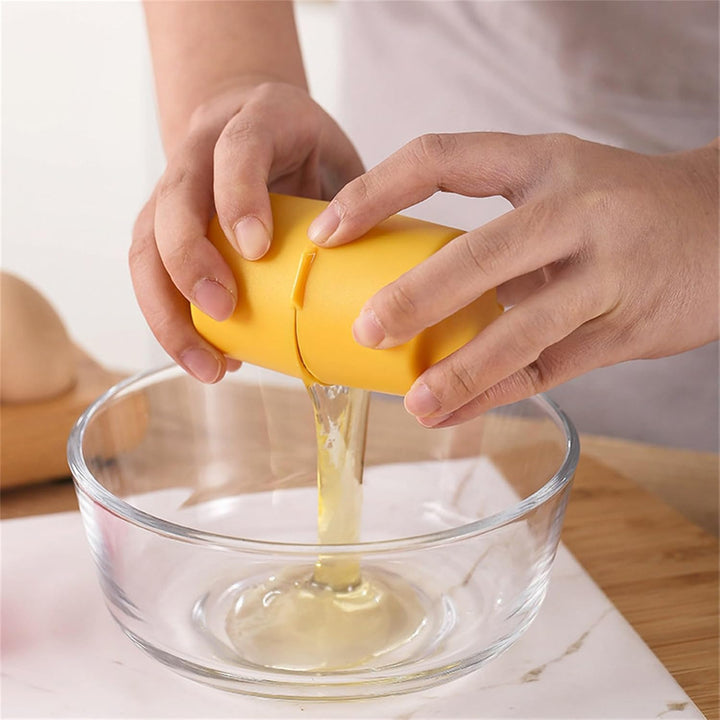 Hand using a yellow egg cracker tool to crack an egg into a glass bowl for cooking