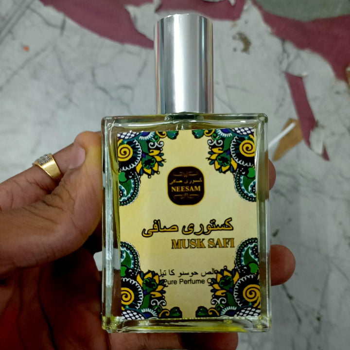 Hand holding musk safi pure perfume 50ml bottle with decorative label and silver cap