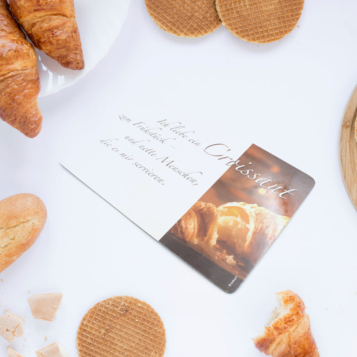 Plastic kitchen chopping board with various pastries including croissants and cookies around it