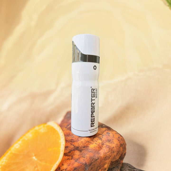 Reporter Midday Fragrance Spray 200ml white bottle placed on a rock with orange slice nearby