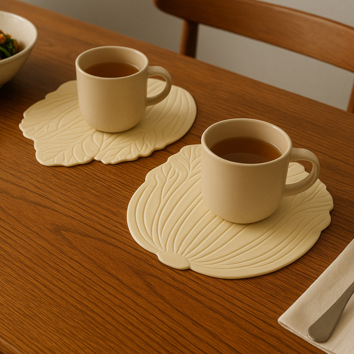 Silicone leaf coasters in cream color with cups on a wooden dining table for elegant home decor