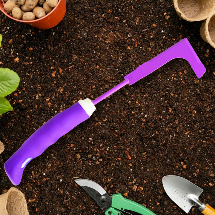 Purple garden tool for soil and plant cultivation tools on fertile soil with seedlings
