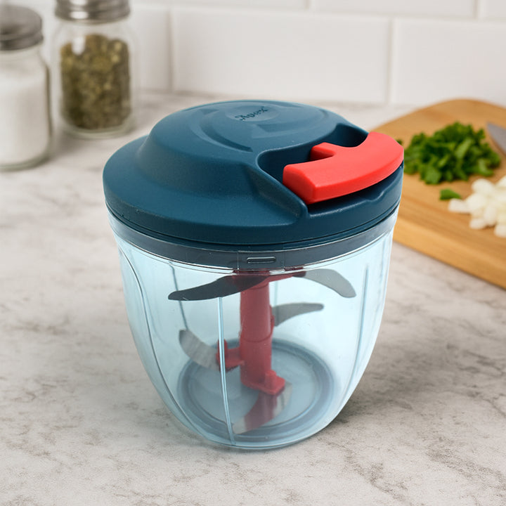 Superior eMart hand-powered vegetable chopper with blue lid and red handle on kitchen counter
