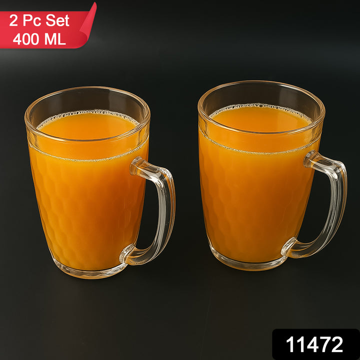 Two 400ml glass mugs for mocktails filled with orange juice on a black background