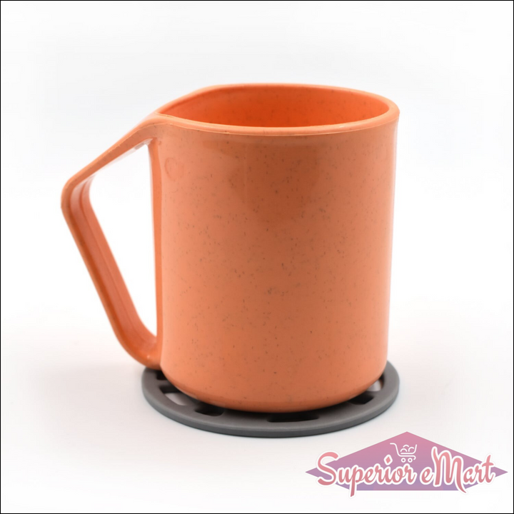Silicone fancy coaster in grey supporting an orange measuring cup on a clean white background