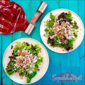 2-in-1 salt and pepper grinder beside two fresh salads on a blue table, enhancing flavor with ease