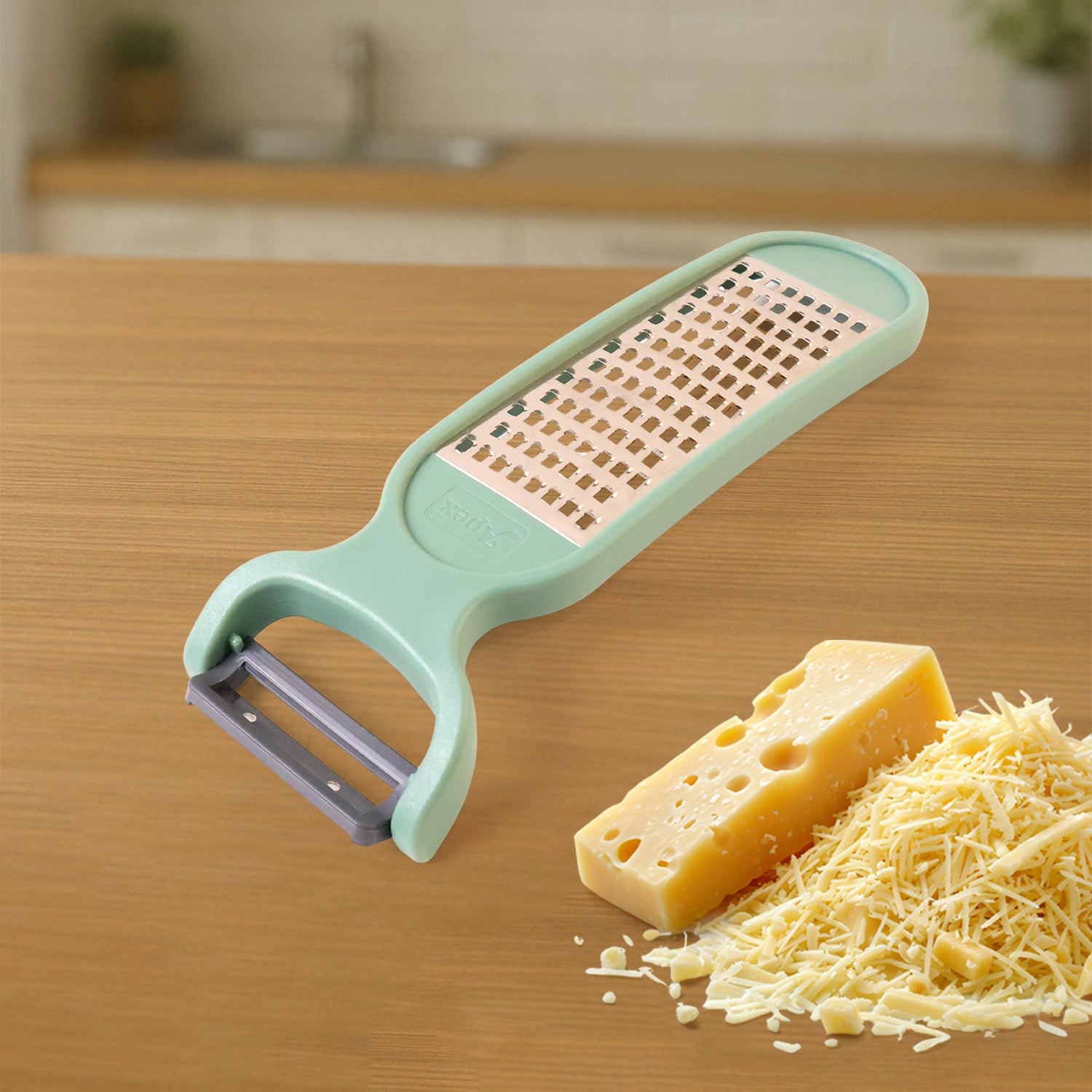 Superior eMart 2-in-1 vegetable grater peeler in mint green with cheese and grated vegetables beside it