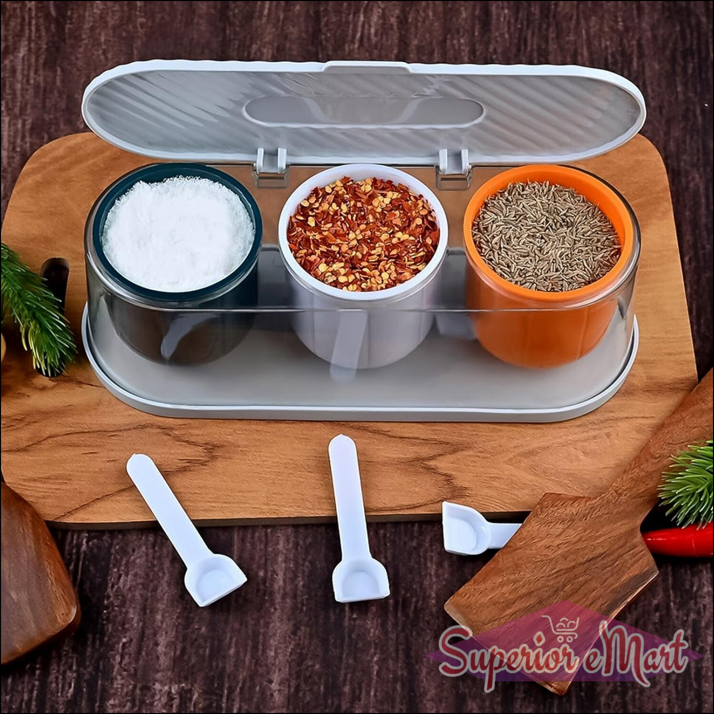 3 grid spice box with spoon, featuring containers for salt, chili flakes, and cumin on a wooden cutting board