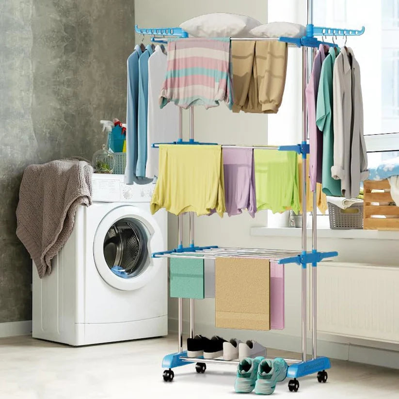3 layer stainless steel cloth drying stand with colorful clothes and towels in a modern laundry room