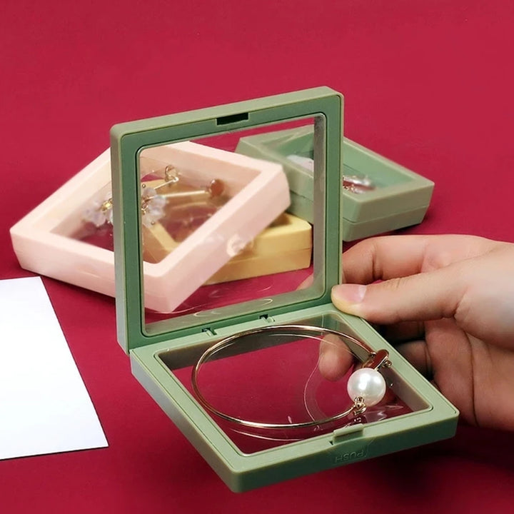 Hand holding a 3D floating display frame 1 pc in green showcasing jewelry pieces inside