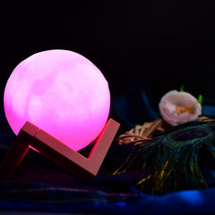 Pink moon lamp with wooden stand for cozy bedroom lighting.