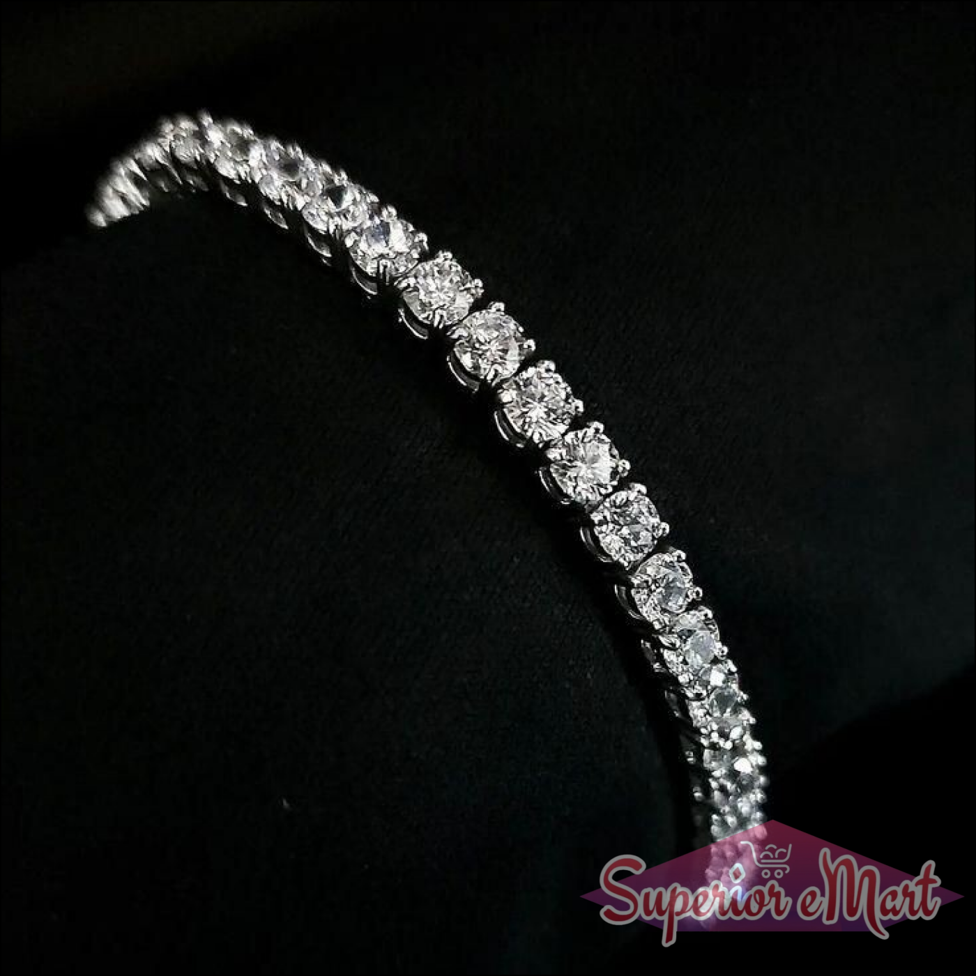 Sparkling diamond tennis bracelet featuring round-cut stones in a silver-toned setting on a black background.