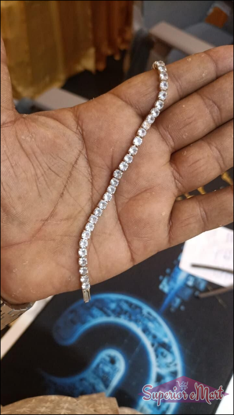 Sparkling silver-tone tennis bracelet with a row of clear round-cut stones, held in an open palm.