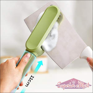 Green and blue cleaning tool being used on a surface with a white background
