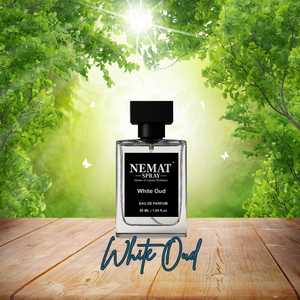 Nemat White Oud perfume bottle with black label and cap on a wooden table with a sunny green forest background.