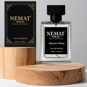 Nemat Heaven Vibes 50ml Eau de Parfum: clear glass bottle and black/gold box on round wooden display stands.