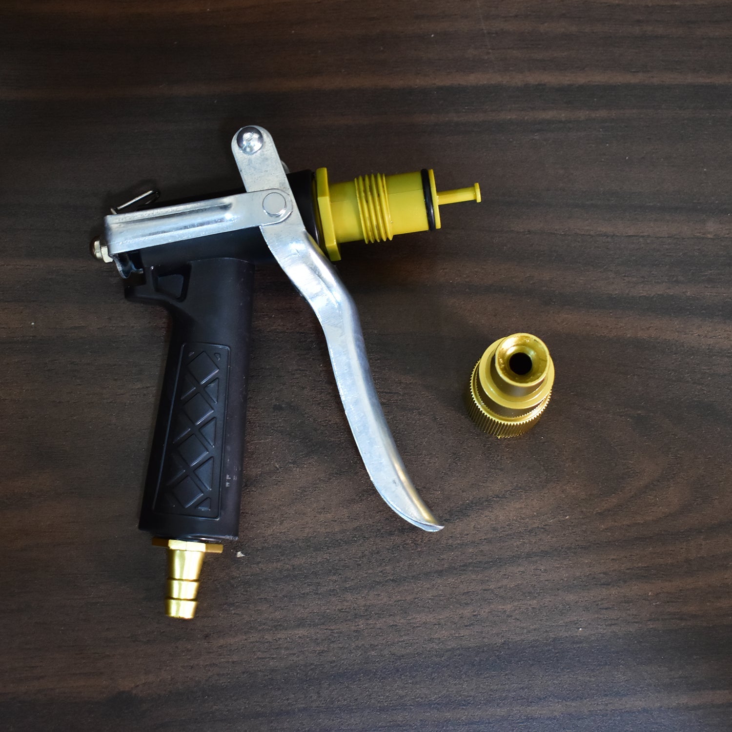 Durable hose nozzle with gold finish, lever design for spraying water.