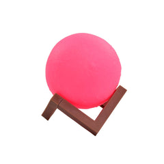 Moon lamp in pink color with wooden stand for bedroom ambiance.