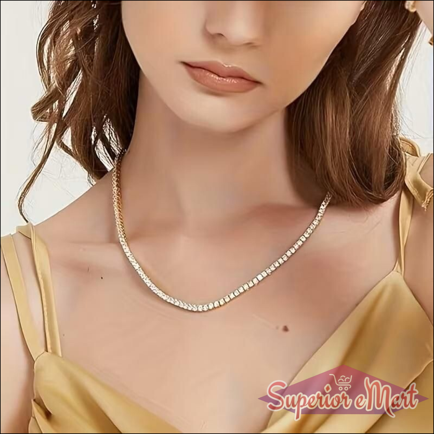 Woman wearing a shimmering gold tennis necklace with small clear stones and a yellow satin top.