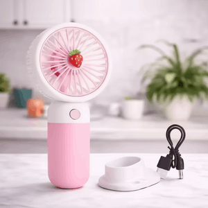 Pink handheld fan with strawberry design on a white surface