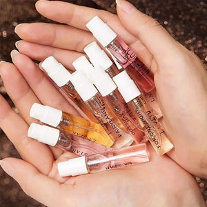 Hands holding 8 Perfumes Gift Box set of small sample perfume spray vials in assorted scents