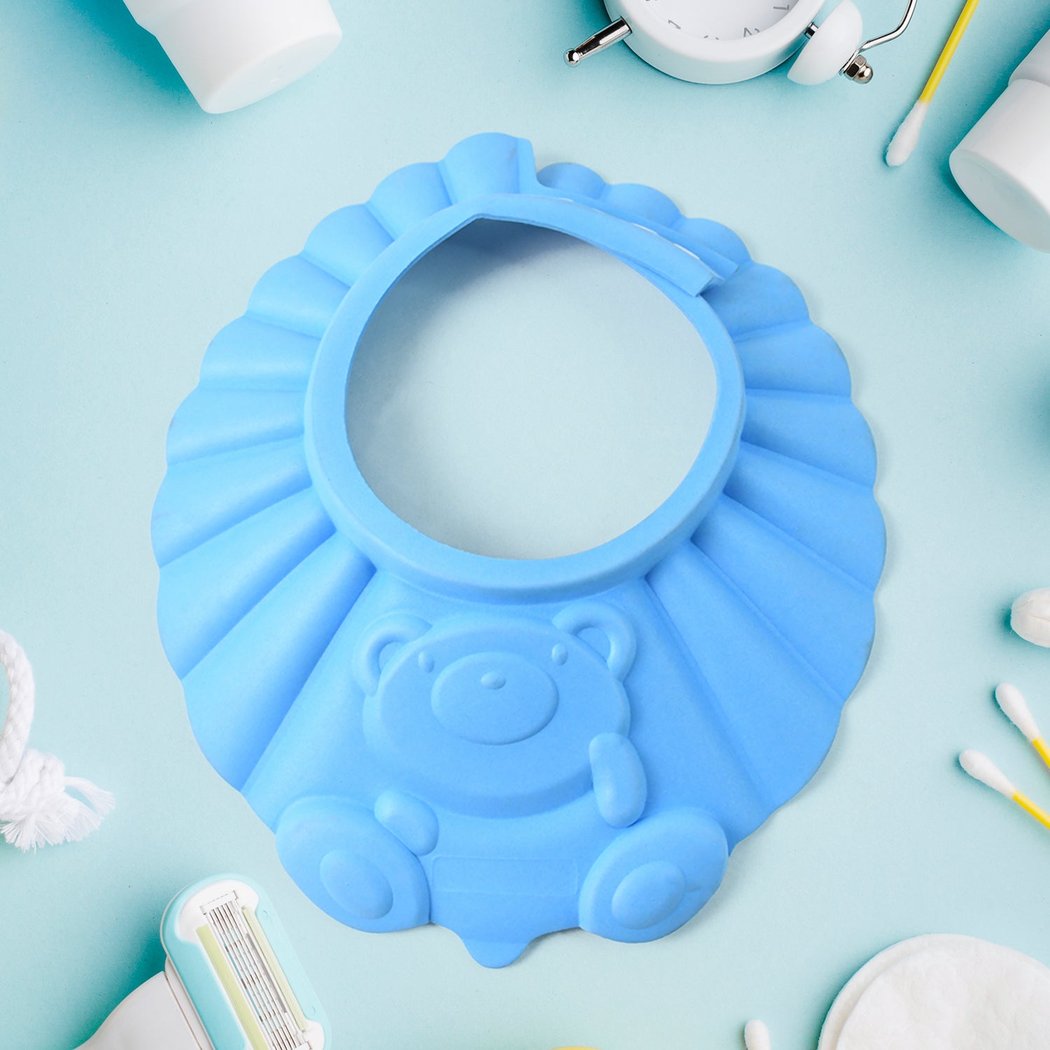 Adjustable baby shower cap in blue with a cute bear design for protecting baby's eyes during bath time