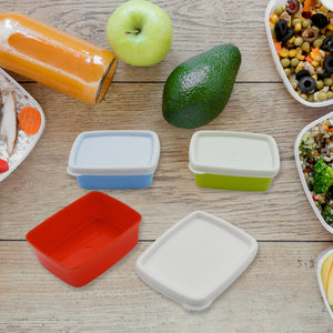 Airtight food storage containers set in various colors with fresh vegetables and healthy meals on a wooden table