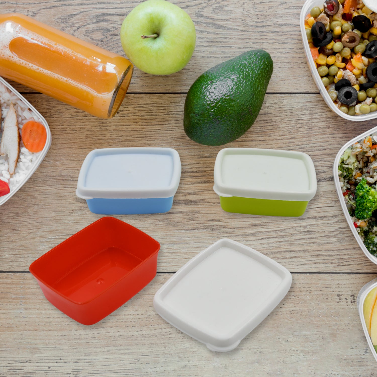 Airtight food storage containers set in various colors with fresh vegetables and healthy meals on a wooden table