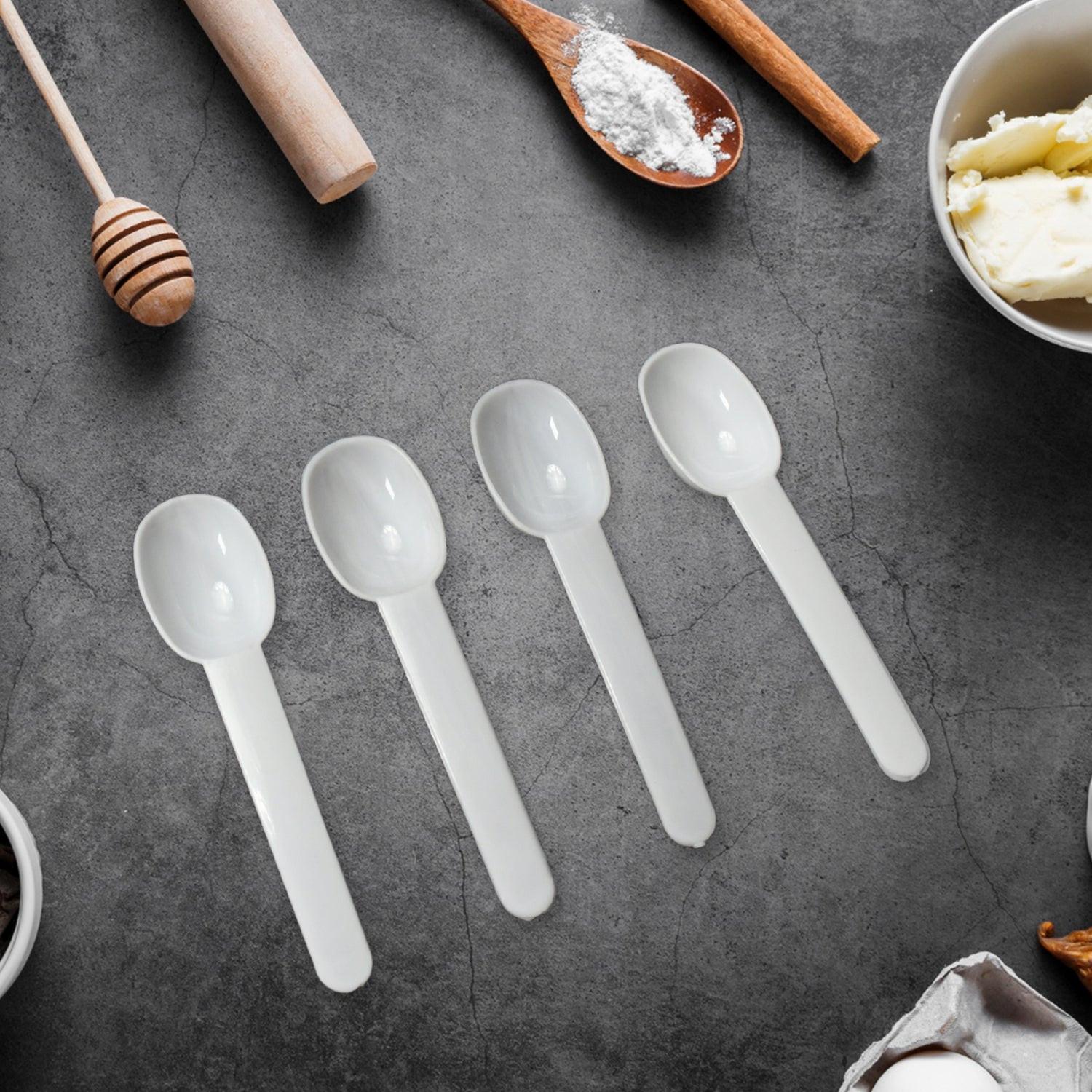 Set of four transparent measuring spoons for precise ingredients in airtight kitchen storage container