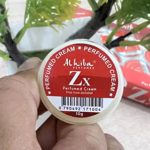 Alhiba Perfumes Zx Perfumed Cream container held by a hand with a blurred background