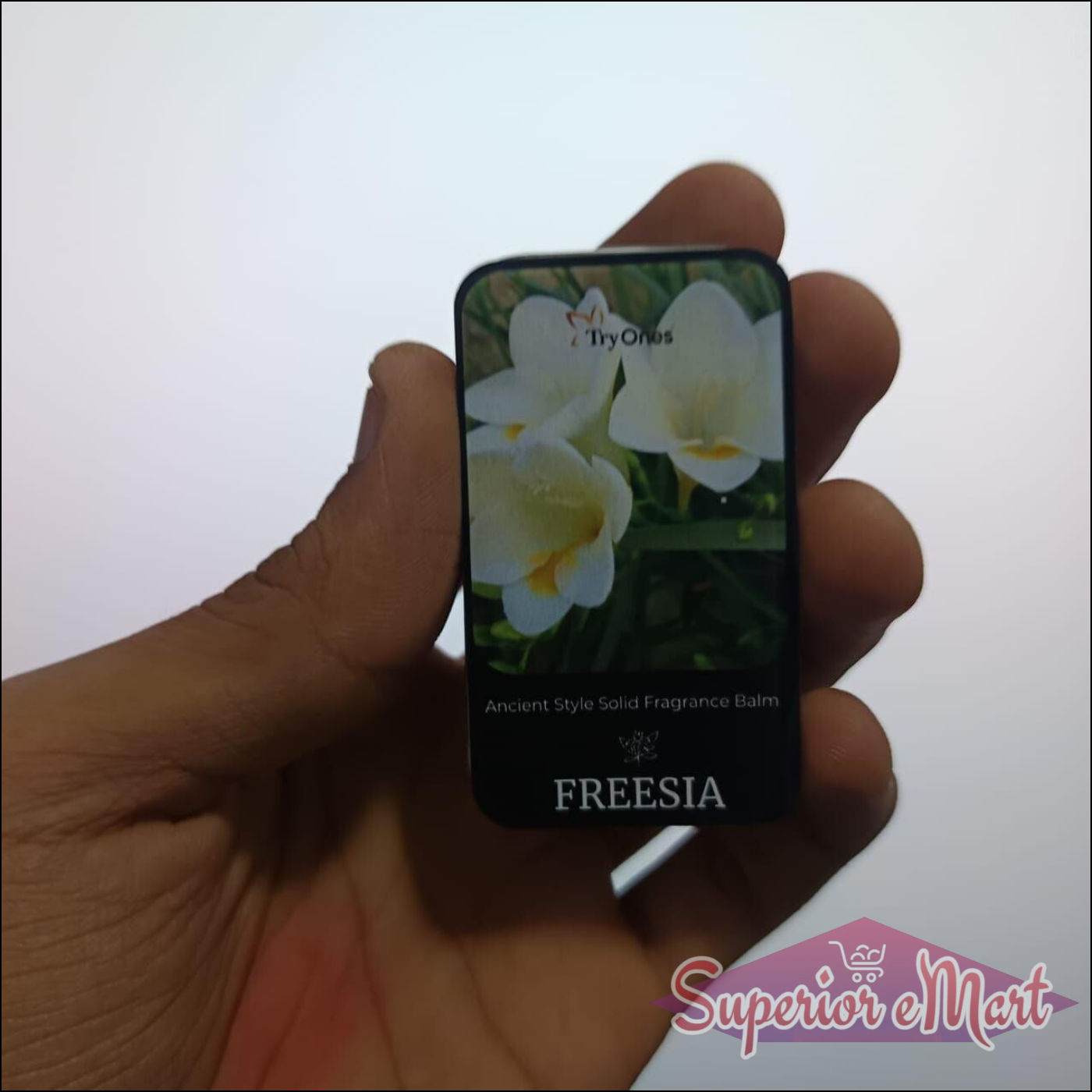 Ancient style solid perfume balm with floral design and Freesia scent, held in hand for demonstration
