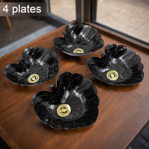 Ceramic tea cup and bowl set displayed on a wooden table with elegant flower-shaped black plates