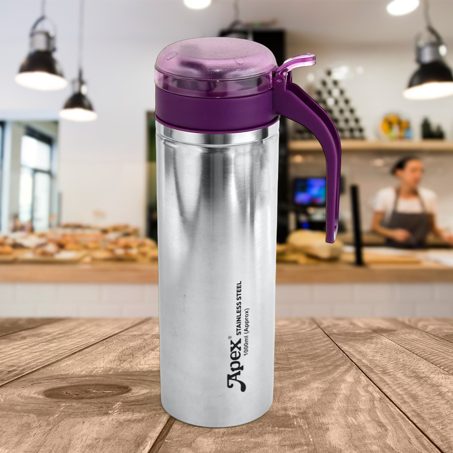 Superior eMart stainless steel oil pourer with purple lid and handle on wooden table in kitchen