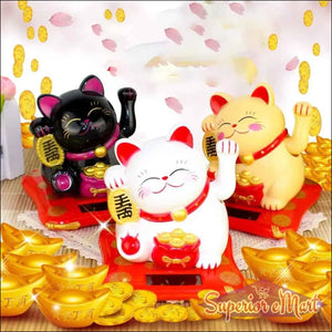Colorful wealth attracting cat figurines in black, white, and gold on a decorative display with gold coins