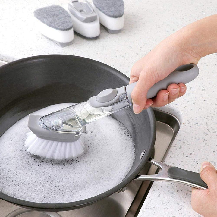 Superior eMart automatic dish scrubber brush cleaning a soapy frying pan with grey handle and refillable soap compartment