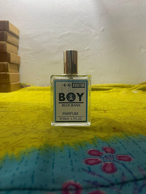 Aviator Boy Blue Jeans fragrance 50ml in clear bottle with gold cap on colorful fabric background