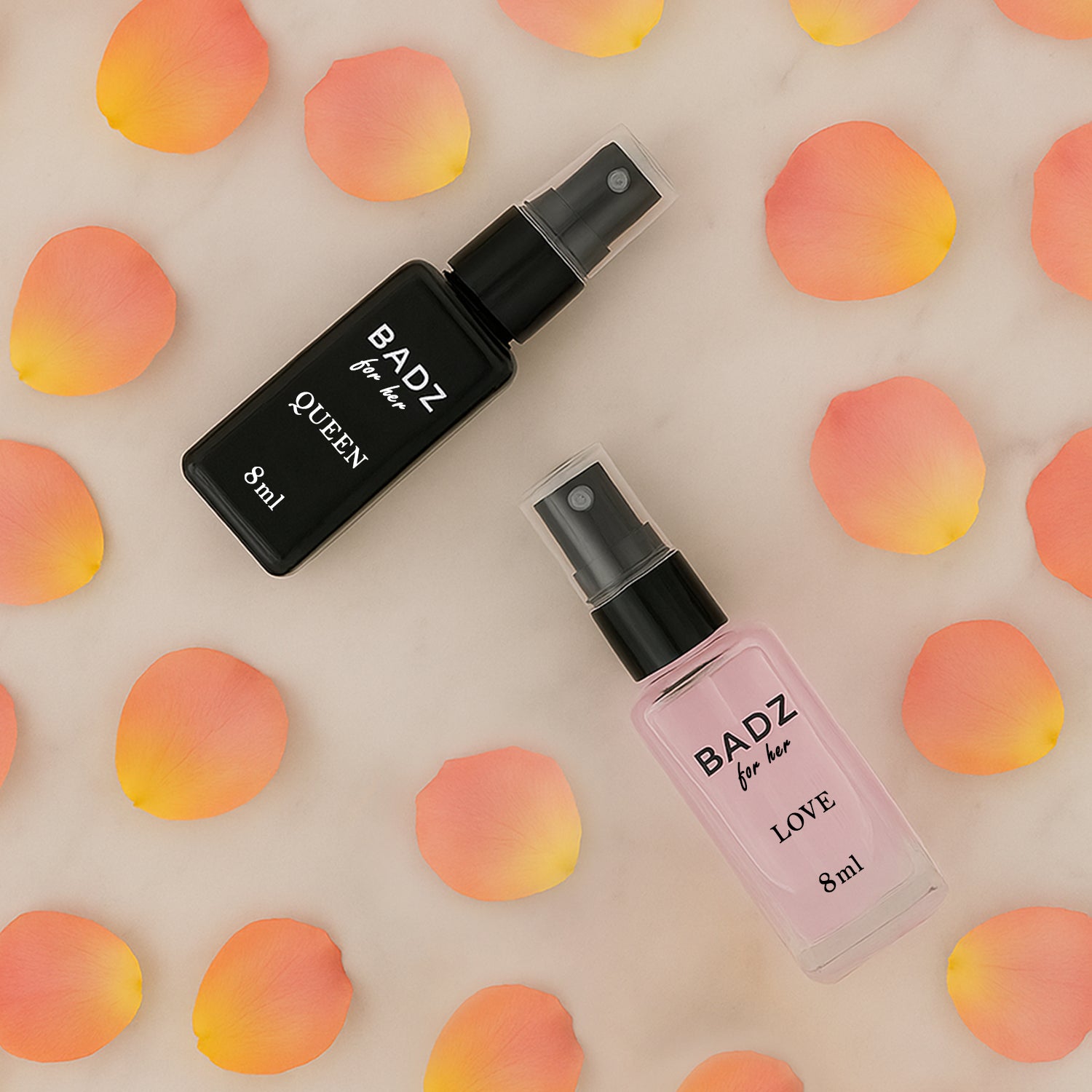 Mini perfume spray set featuring BADZ Queen and BADZ Love in stylish bottles on a petal background