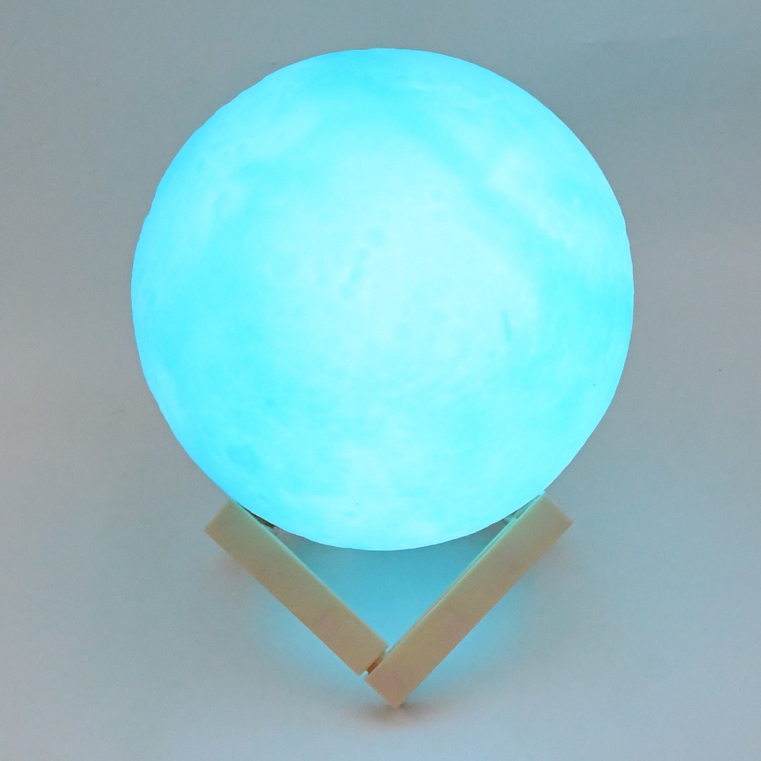 Blue moon night lamp with a soft glow on a minimalist wooden base for calming home decor