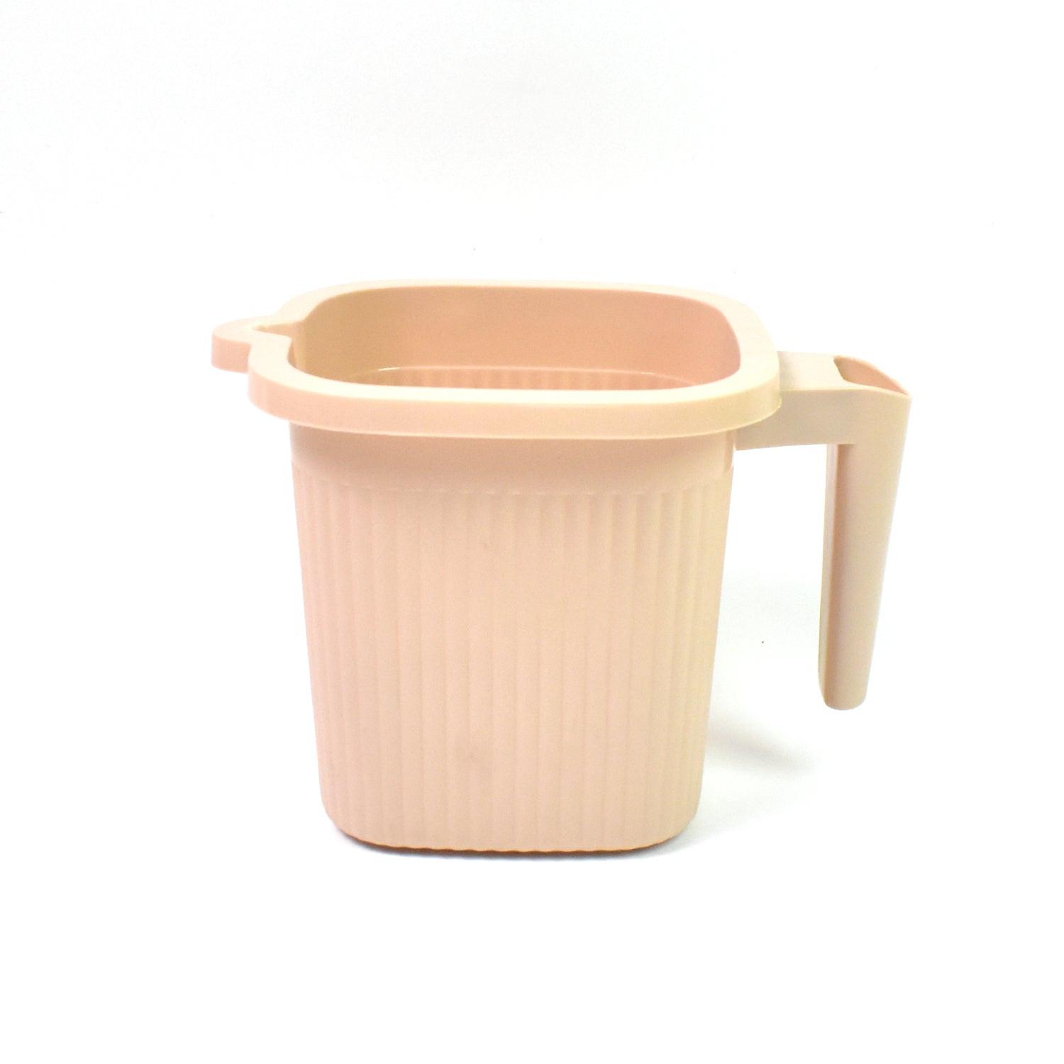 BPA free bath mug in soft pink color with a sturdy handle for easy use in the bathroom