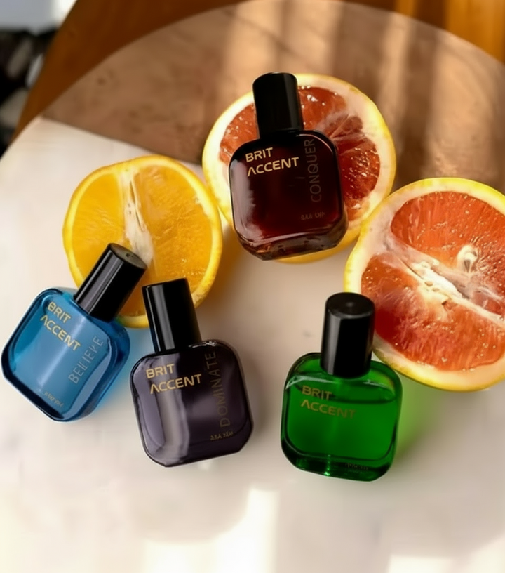 Luxury gift set for men featuring four distinct perfume bottles on a countertop with fresh citrus fruits