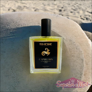 Capricorn Zodiac Unisex Perfume 50ml in a stylish bottle against a sandy background