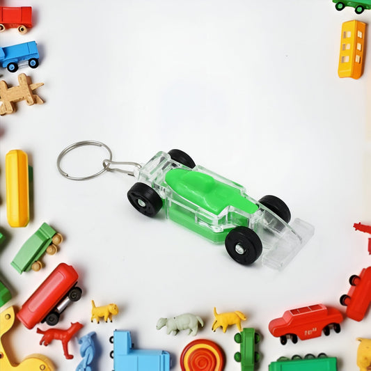 Transparent car shaped keychain with green details surrounded by colorful toy vehicles