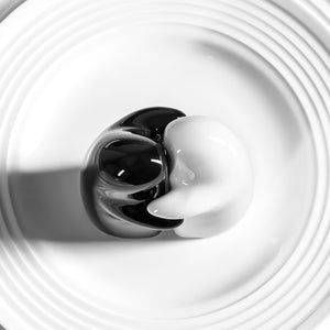Superior eMart ceramic spice shaker set in black and white on a white ridged plate