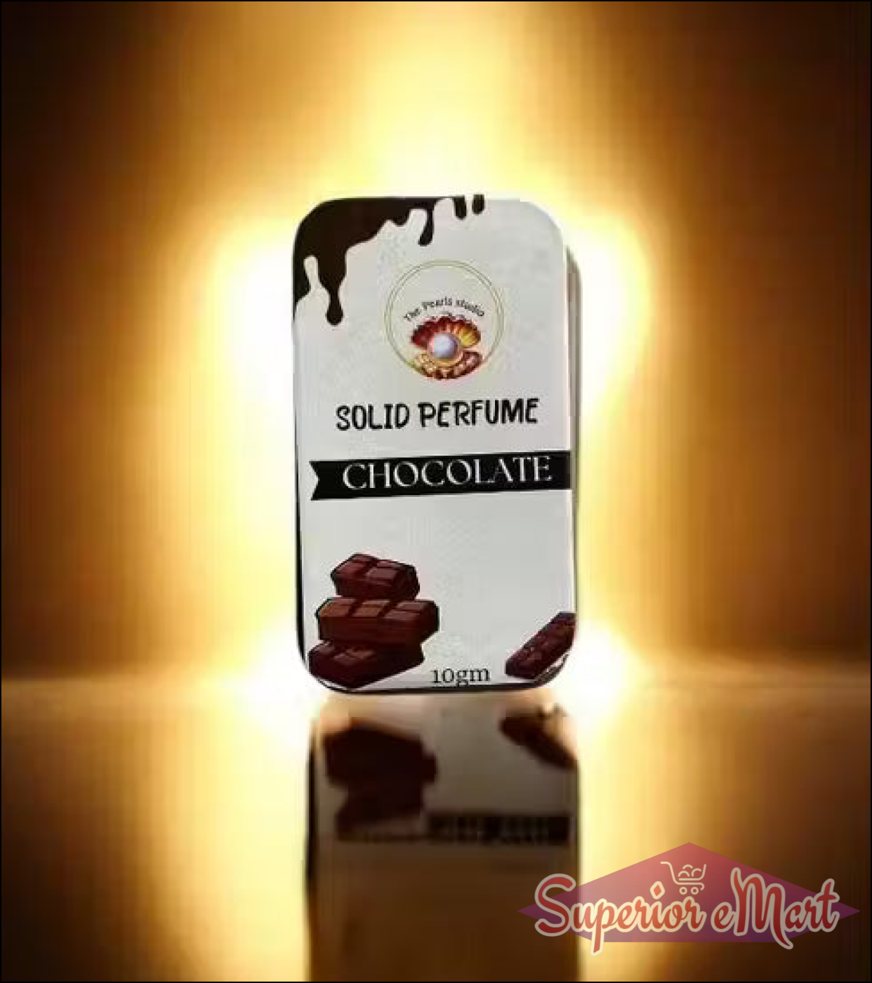 The Pearl Studio Chocolate Solid Perfume 10g tin with chocolate art, set against a warm, golden glowing background.