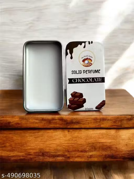 Chocolate solid perfume balm in a sleek tin container on a wooden surface